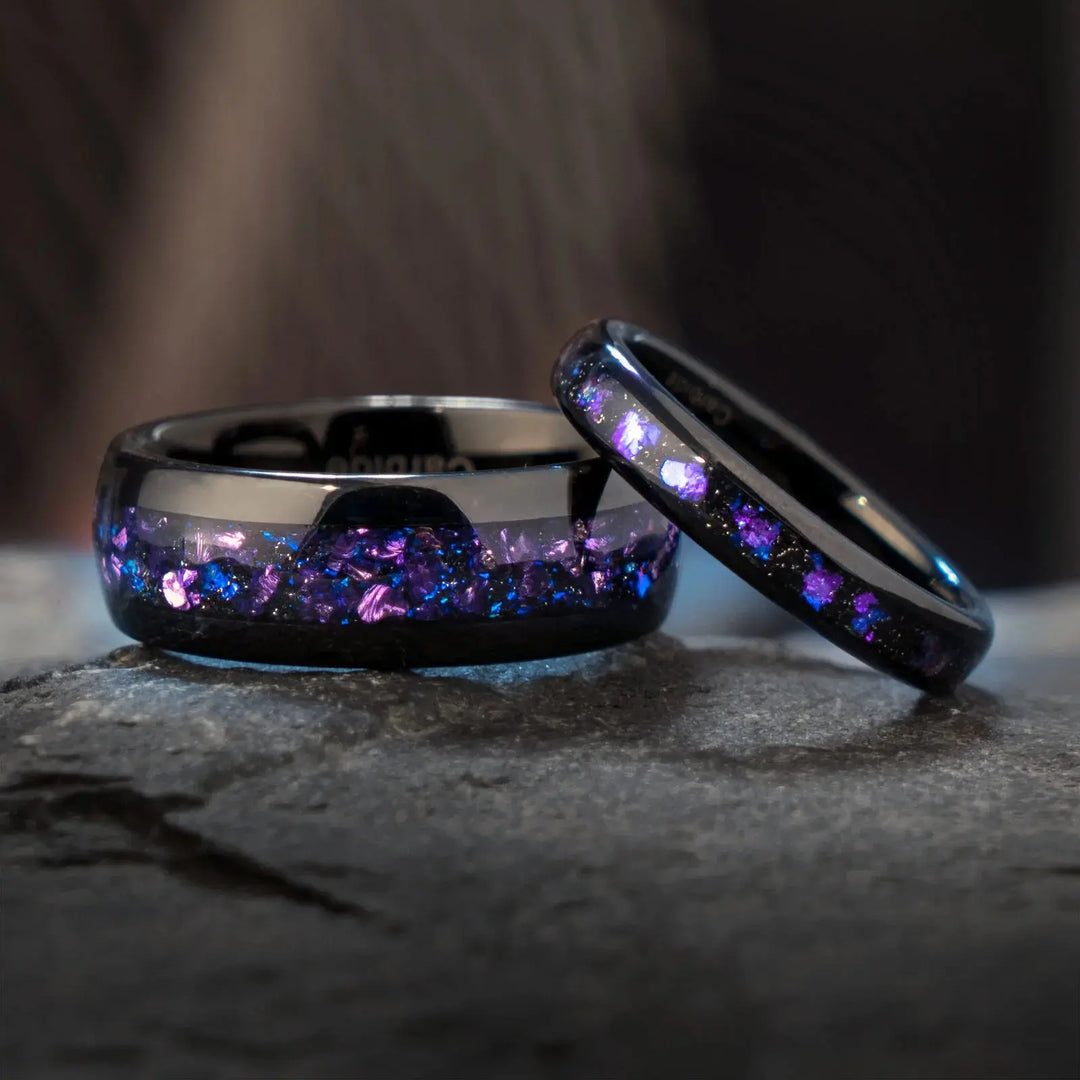 Capricornus black tungsten wedding rings from CouplesChoices.com, featuring crushed Alexandrite inlays with shifting violet and blue tones, designed for a bold and cosmic-inspired look.