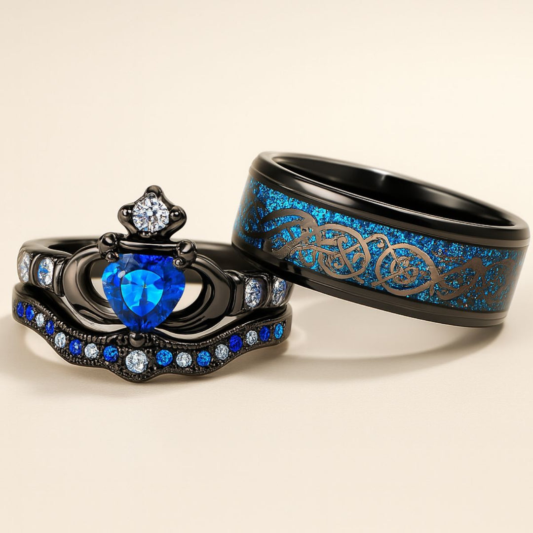 Elegant black titanium Unending Love ring set by CouplesChoices.com, featuring a sapphire heart, pavé-set stones, and a Celtic infinity pattern symbolizing eternal love.