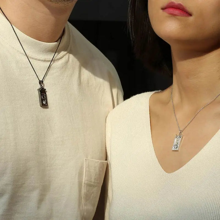 Matching King and Queen necklaces from CouplesChoices.com—black crown pendant with “K” for him and silver gem-framed pendant with “Q” for her. A bold, regal expression of love, loyalty, and royal couple energy.