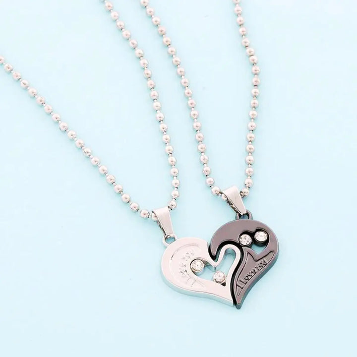 Matching couple necklaces from CouplesChoices.com featuring interlocking black and silver heart pendants engraved with “I Love You” and crystal accents—symbolizing unity, deep love, and everlasting connection.