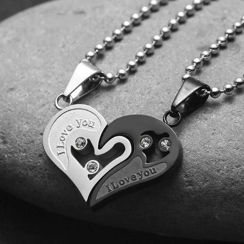 Matching couple necklaces from CouplesChoices.com featuring interlocking black and silver heart pendants engraved with “I Love You” and crystal accents—symbolizing unity, deep love, and everlasting connection.