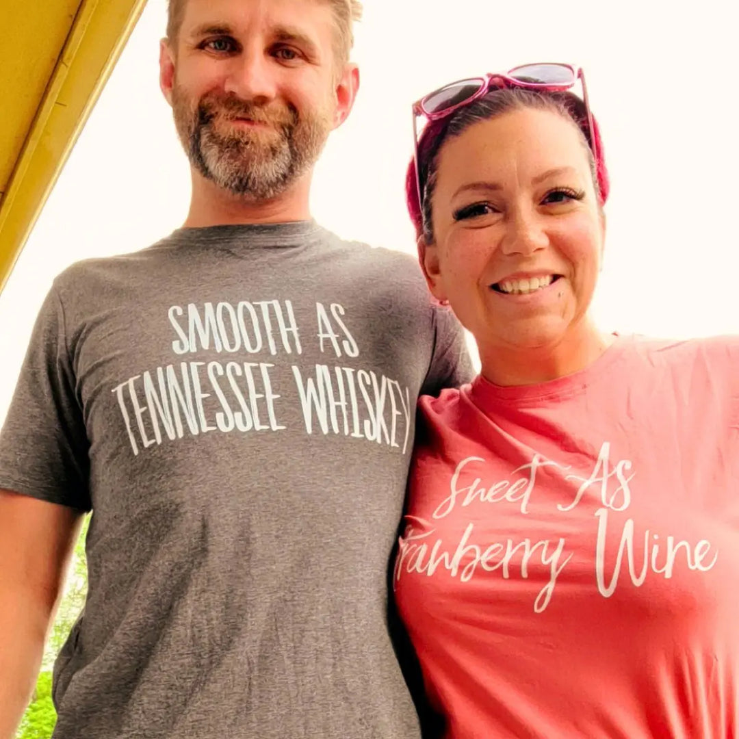 Matching couple shirts from CouplesChoices.com—his in charcoal gray reads “Smooth As Tennessee Whiskey,” hers in berry red says “Sweet As Strawberry Wine.” A stylish, country-inspired tribute to love, flavor, and southern charm.