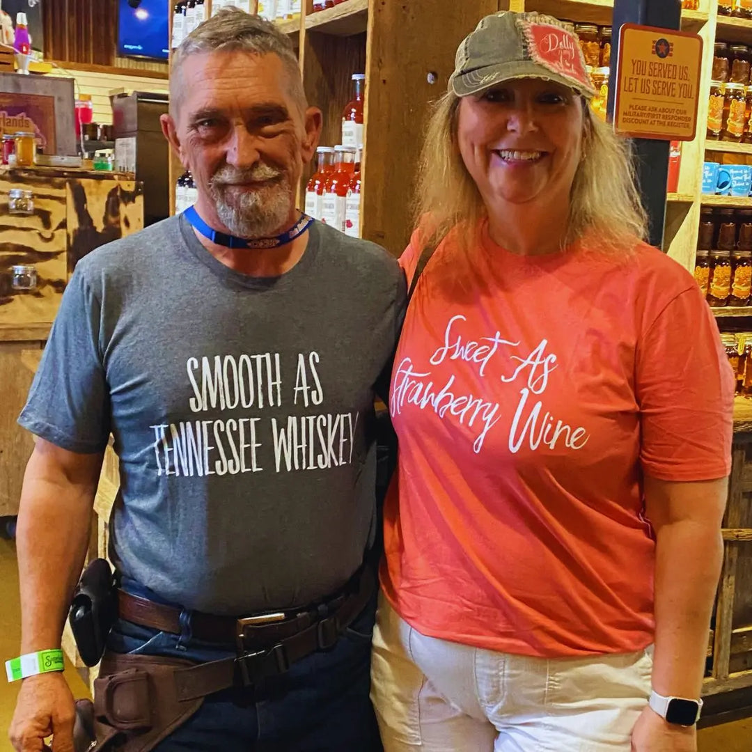 Matching couple shirts from CouplesChoices.com—his in charcoal gray reads “Smooth As Tennessee Whiskey,” hers in berry red says “Sweet As Strawberry Wine.” A stylish, country-inspired tribute to love, flavor, and southern charm.