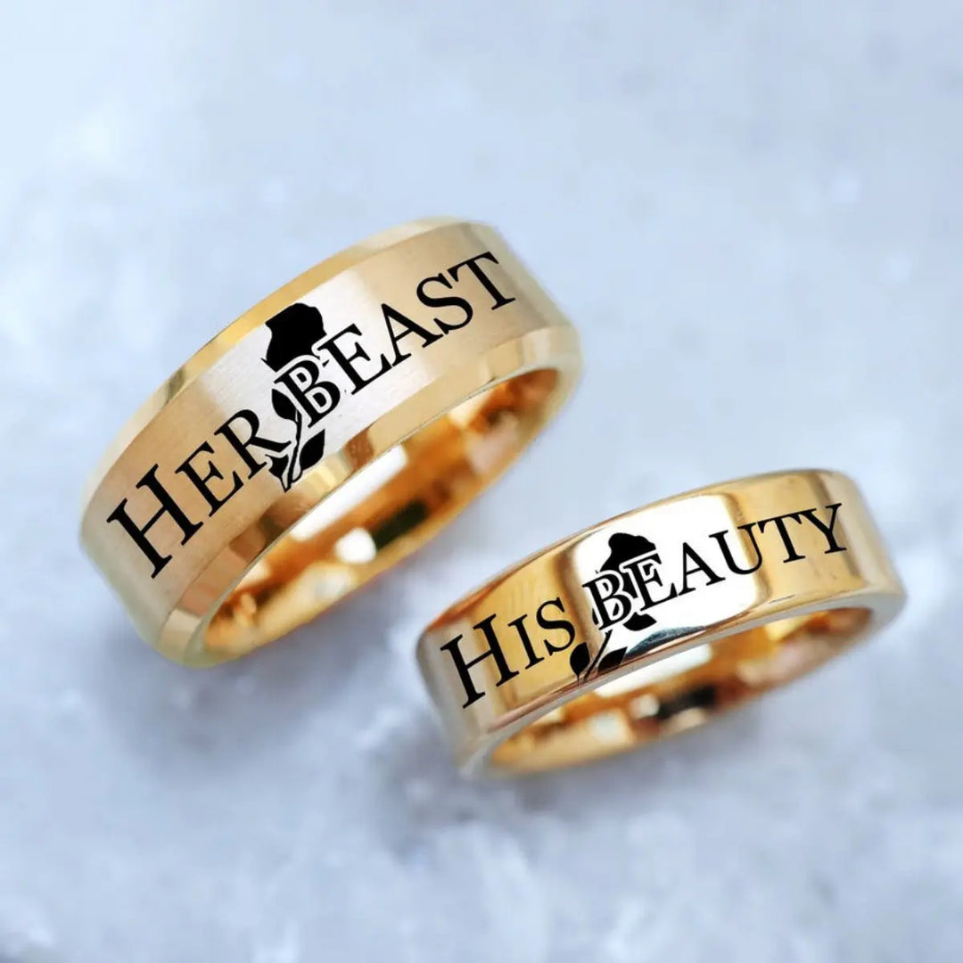 Celebrate timeless love with the Demure Rose Rings from CouplesChoices.com—gold bands engraved with “Her Beast” and “His Beauty,” symbolizing a powerful, elegant bond inspired by a tale as old as time.