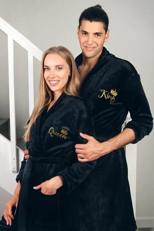 Elegant black his-and-hers bathrobes from CouplesChoices.com, featuring gold embroidered “King” and “Queen” lettering with royal crown accents—luxurious, coordinated loungewear designed to celebrate love, royalty, and refined comfort.