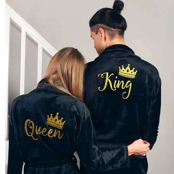 Elegant black his-and-hers bathrobes from CouplesChoices.com, featuring gold embroidered “King” and “Queen” lettering with royal crown accents—luxurious, coordinated loungewear designed to celebrate love, royalty, and refined comfort.