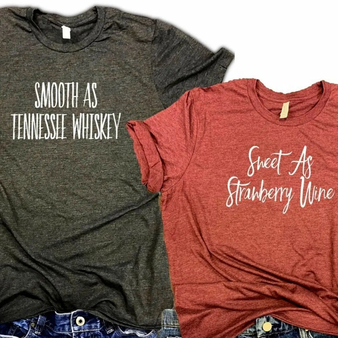 Matching couple shirts from CouplesChoices.com—his in charcoal gray reads “Smooth As Tennessee Whiskey,” hers in berry red says “Sweet As Strawberry Wine.” A stylish, country-inspired tribute to love, flavor, and southern charm.
