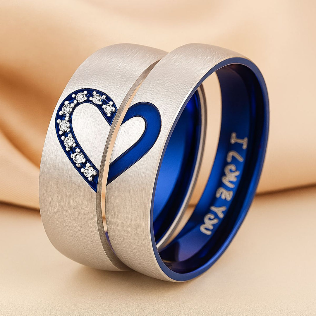 Adore Rings by CouplesChoices.com – brushed silver matching couple rings with sapphire blue interior, forming a heart when placed together. One ring features sparkling cubic zirconia stones, symbolizing unity and eternal love.