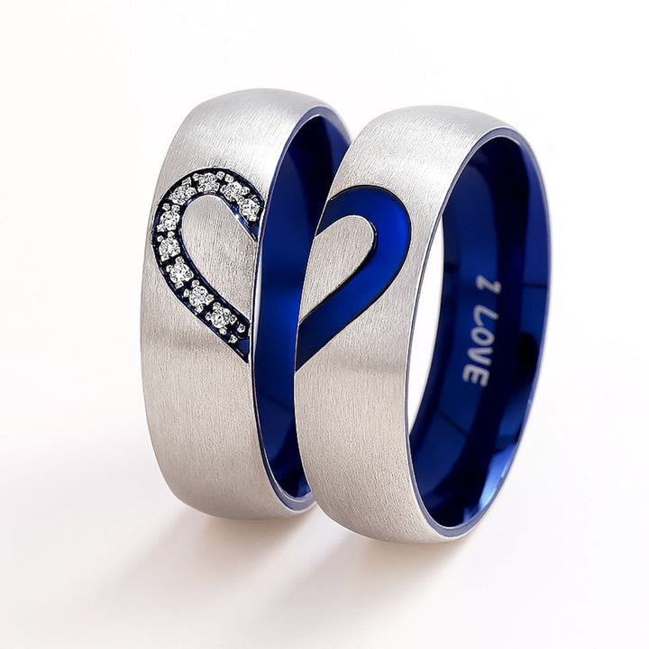 Adore Rings by CouplesChoices.com – brushed silver matching couple rings with sapphire blue interior, forming a heart when placed together. One ring features sparkling cubic zirconia stones, symbolizing unity and eternal love.