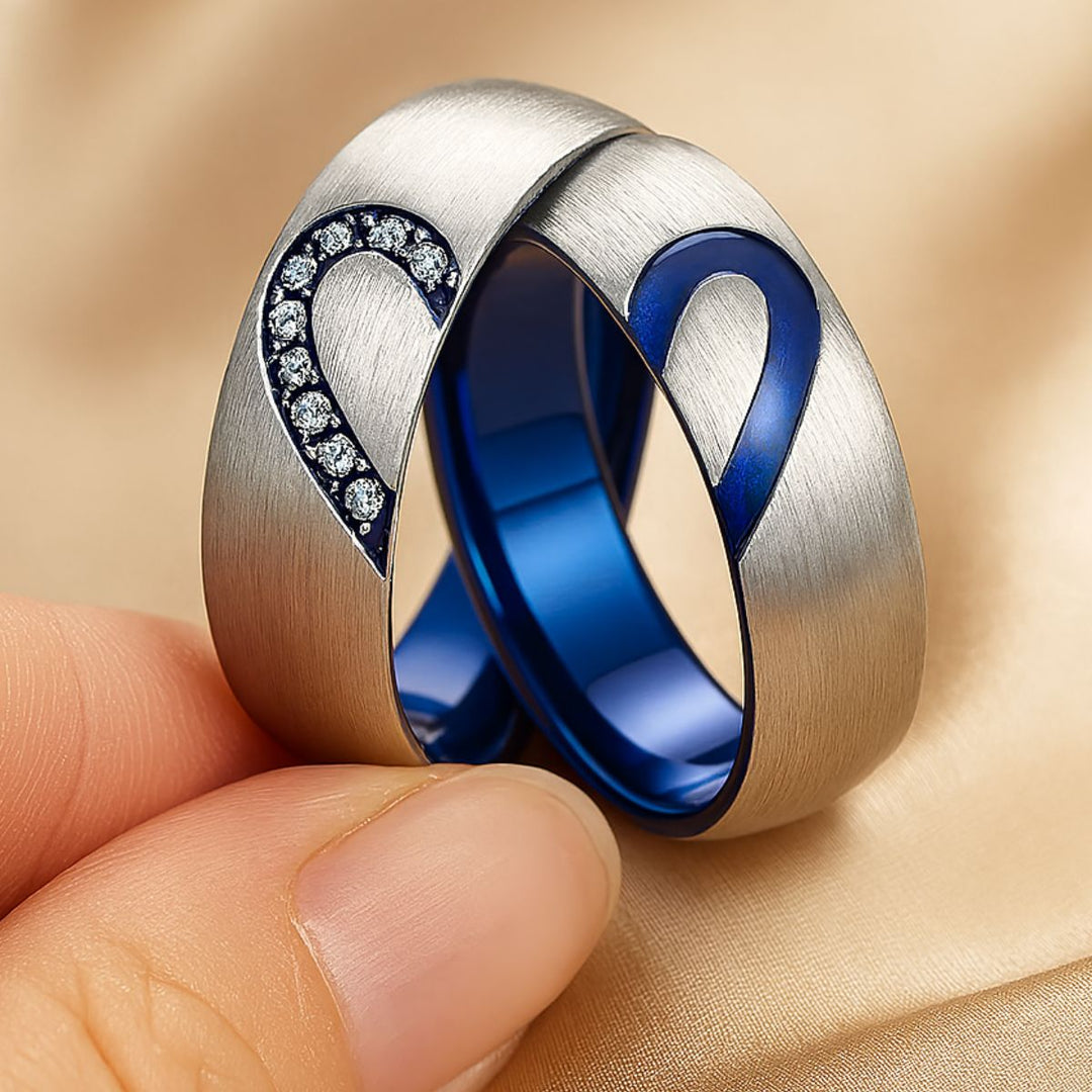 Adore Rings by CouplesChoices.com – brushed silver matching couple rings with sapphire blue interior, forming a heart when placed together. One ring features sparkling cubic zirconia stones, symbolizing unity and eternal love.