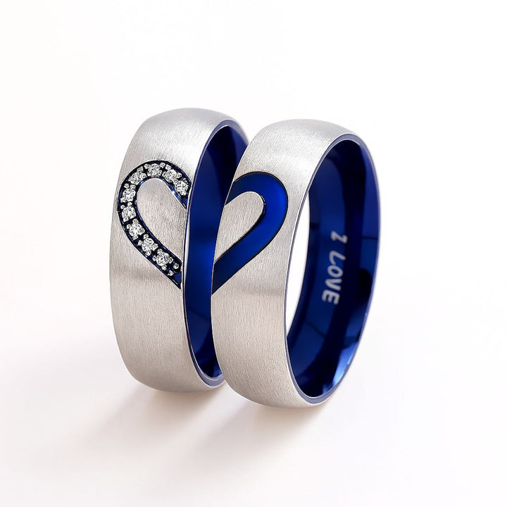Adore Rings by CouplesChoices.com – brushed silver matching couple rings with sapphire blue interior, forming a heart when placed together. One ring features sparkling cubic zirconia stones, symbolizing unity and eternal love.