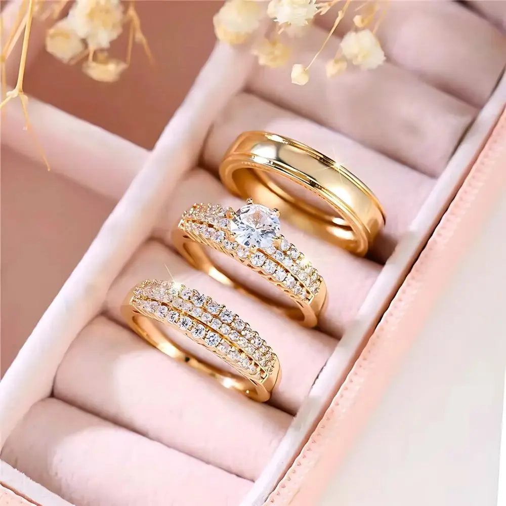 Allure Ring Set by CouplesChoices.com – a captivating 3-piece gold collection featuring a brilliant round-cut solitaire engagement ring, dual pavé-set eternity bands, and a sleek, polished men’s band. Crafted for timeless romance.