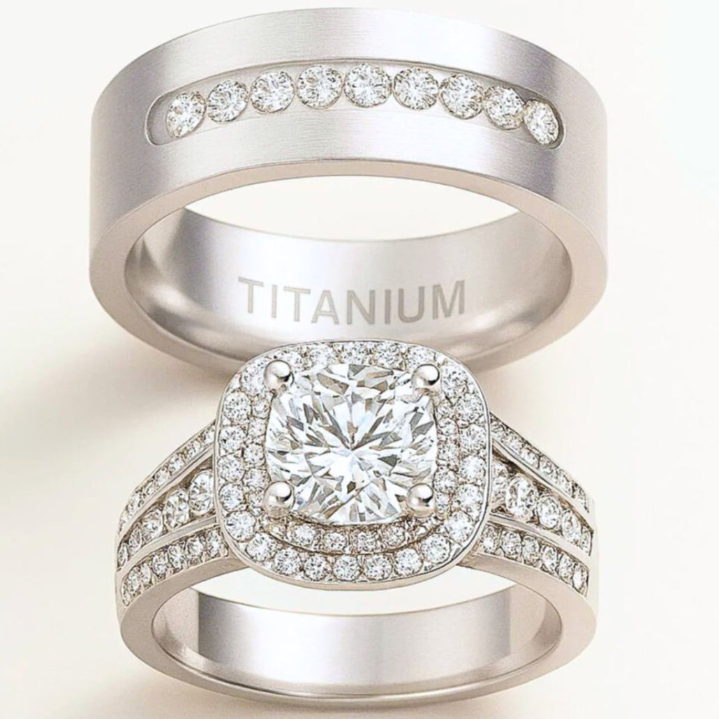 Aurora Rings by CouplesChoices.com – a breathtaking titanium wedding set featuring a cushion-cut center stone, double halo pavé design, and a sleek men’s band with channel-set brilliance for a timeless, luxurious finish.