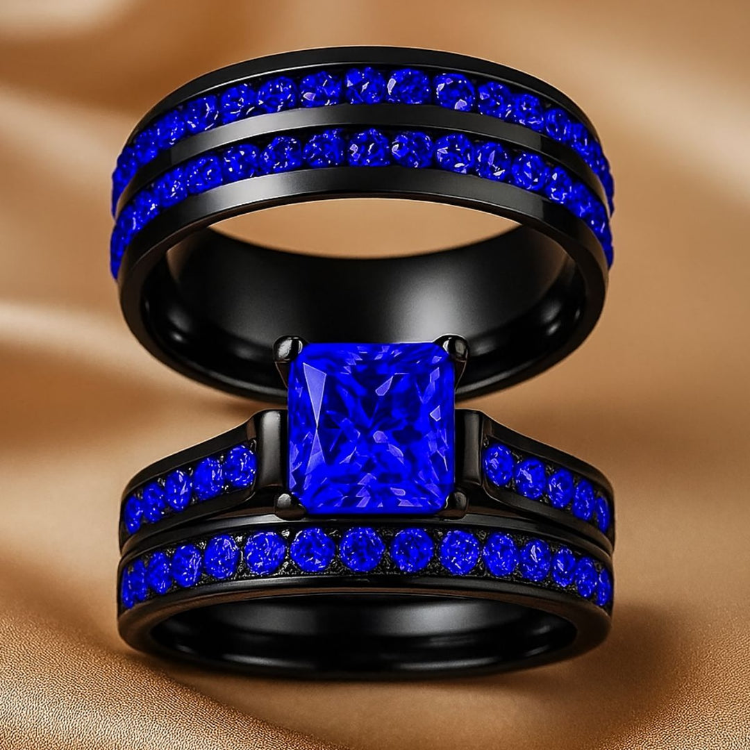 Blue Inspiration Ring Set by CouplesChoices.com featuring a radiant-cut sapphire-blue center stone on a sleek black band, flanked by pavé-set royal blue stones, paired with a matching eternity-style men’s band—crafted for bold connection.