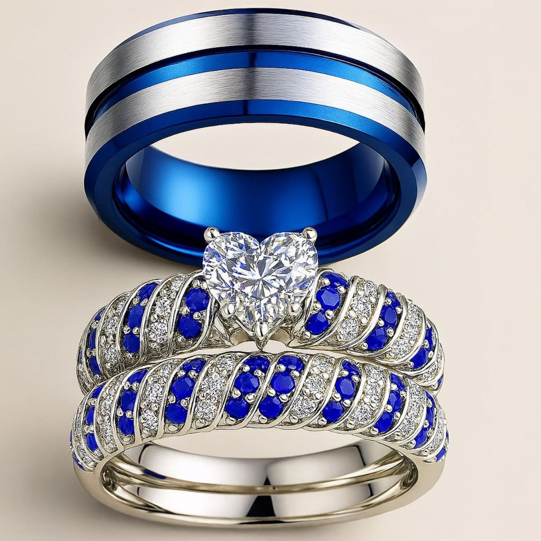 Blue Ocean wedding ring set from CouplesChoices.com, featuring a heart-shaped center stone flanked by pavé-set blue and white crystals in a twisted silver band, paired with a brushed silver and cobalt blue men's band.
