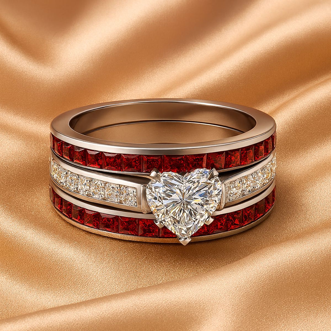 Bold and romantic, the Love Passion Rings by CouplesChoices.com feature a heart-shaped diamond centerpiece, flanked by radiant red inlays and shimmering pavé-set stones, symbolizing eternal devotion in striking style.
