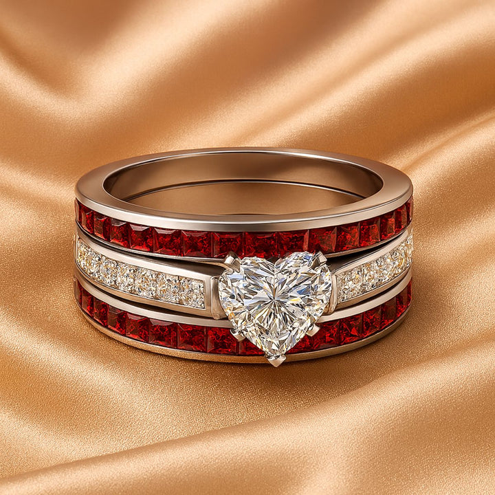 Bold and romantic, the Love Passion Rings by CouplesChoices.com feature a heart-shaped diamond centerpiece, flanked by radiant red inlays and shimmering pavé-set stones, symbolizing eternal devotion in striking style.