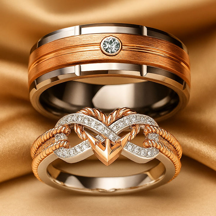 CouplesChoices.com Love Again Rings – Matching set with a men’s brushed rose gold and tungsten band featuring a bezel-set diamond, and a women’s infinity-heart ring in rose gold and pavé diamonds. Elegant symbols of timeless love.