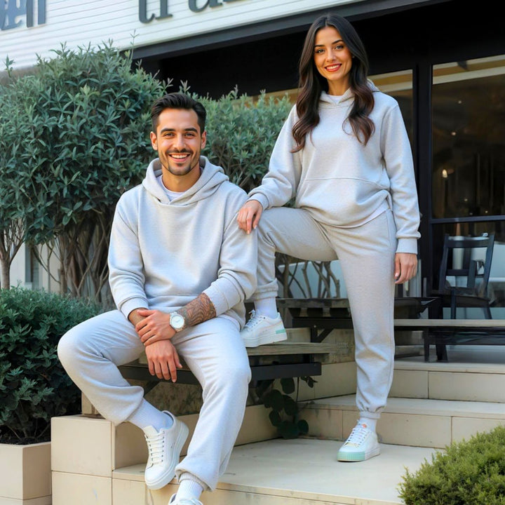 Couples confidently showcasing matching grey tracksuits from CouplesChoices.com, blending elevated comfort and minimalist style—ideal for modern loungewear or coordinated casual outings.