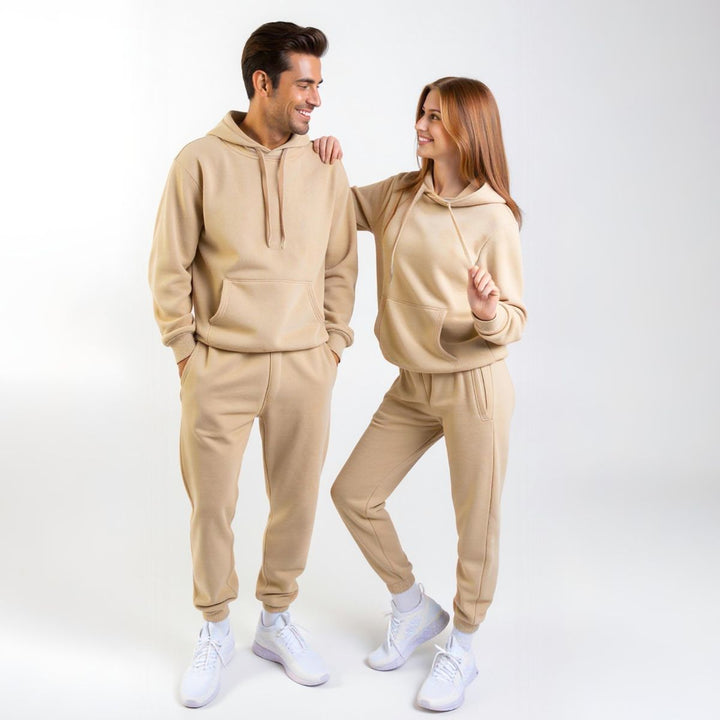 Couples wearing matching beige tracksuits from CouplesChoices.com, showcasing coordinated loungewear with a modern, minimalist design—perfect for casual outings or cozy indoor wear.