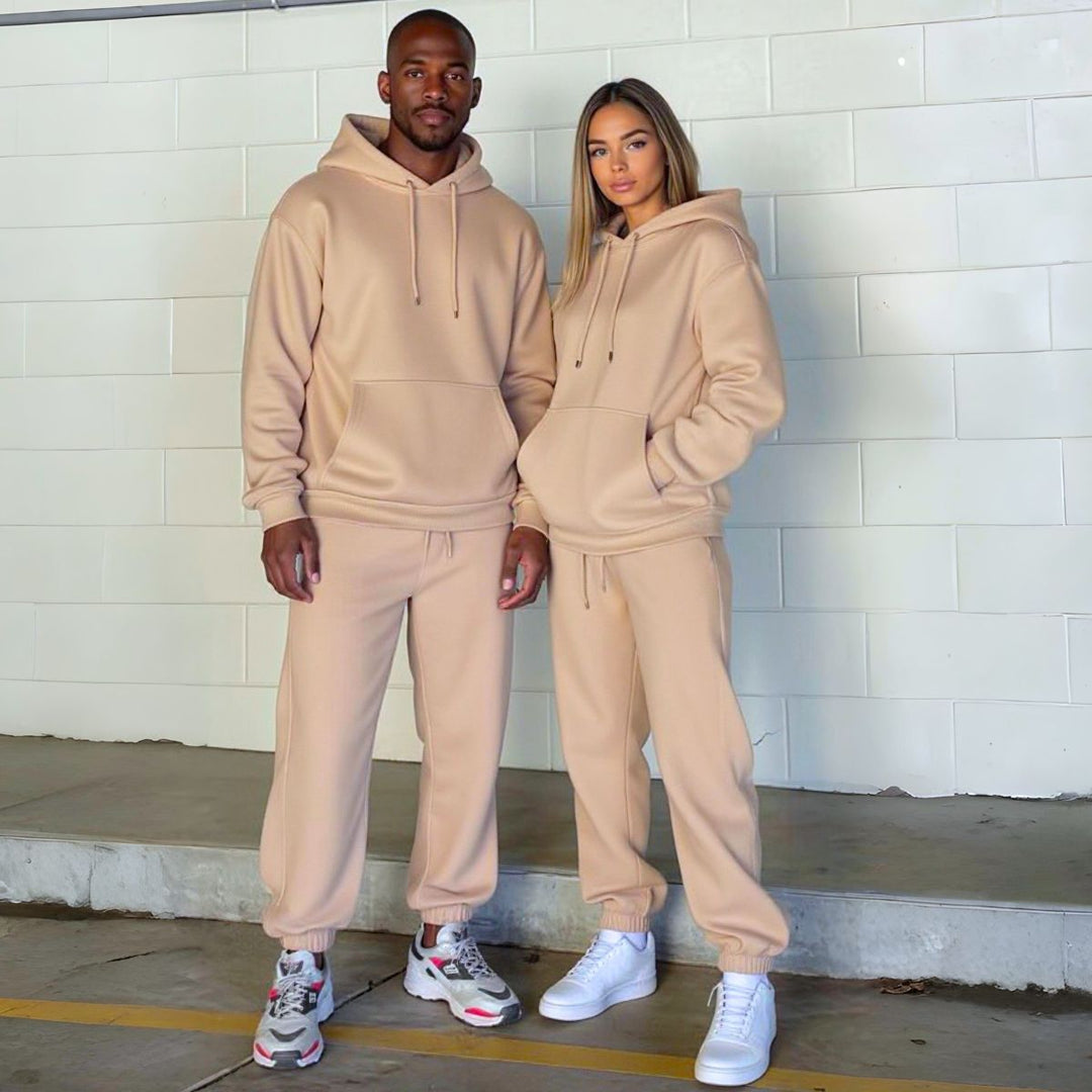 Couples wearing matching beige tracksuits from CouplesChoices.com, showcasing coordinated loungewear with a modern, minimalist design—perfect for casual outings or cozy indoor wear.