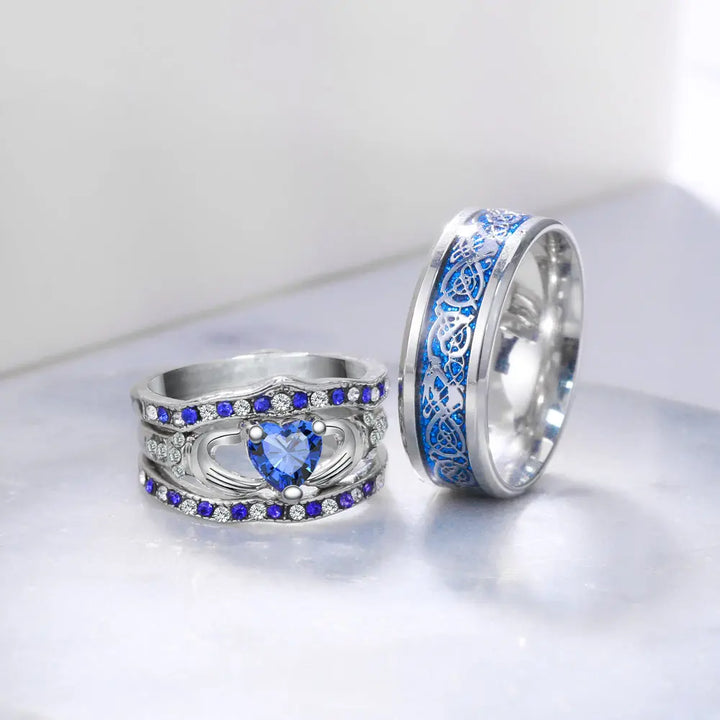 Deep Love Rings by CouplesChoices.com, featuring radiant sapphire-blue stones, Celtic-inspired details, and heart-shaped brilliance—crafted to celebrate powerful, lasting bonds with bold elegance.
