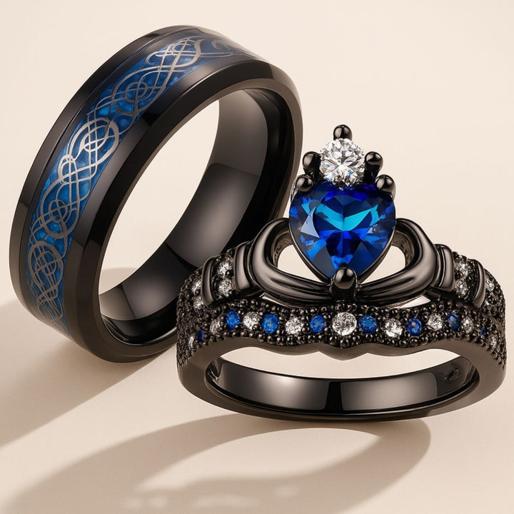 Elegant black titanium Unending Love ring set by CouplesChoices.com, featuring a sapphire heart, pavé-set stones, and a Celtic infinity pattern symbolizing eternal love.