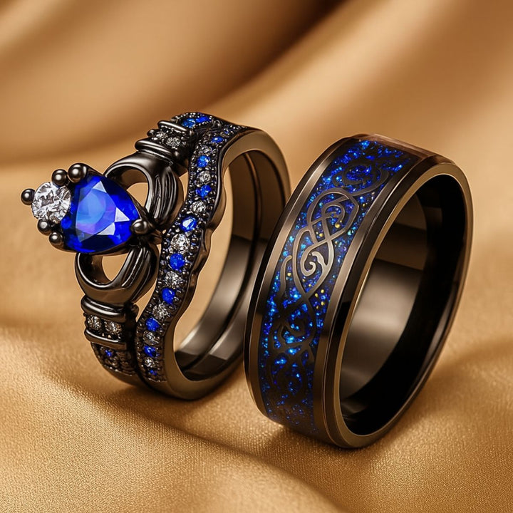 Elegant black titanium Unending Love ring set by CouplesChoices.com, featuring a sapphire heart, pavé-set stones, and a Celtic infinity pattern symbolizing eternal love.