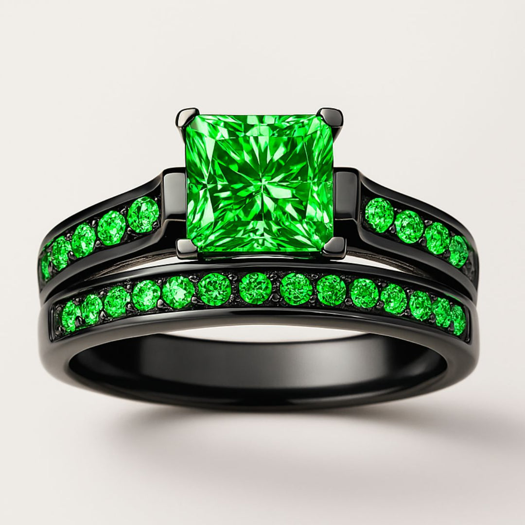 Emerald Breath Ring Set by CouplesChoices.com featuring a princess-cut green center stone on a black pavé band, paired with a brushed black men’s ring accented by a vivid emerald-green inlay.