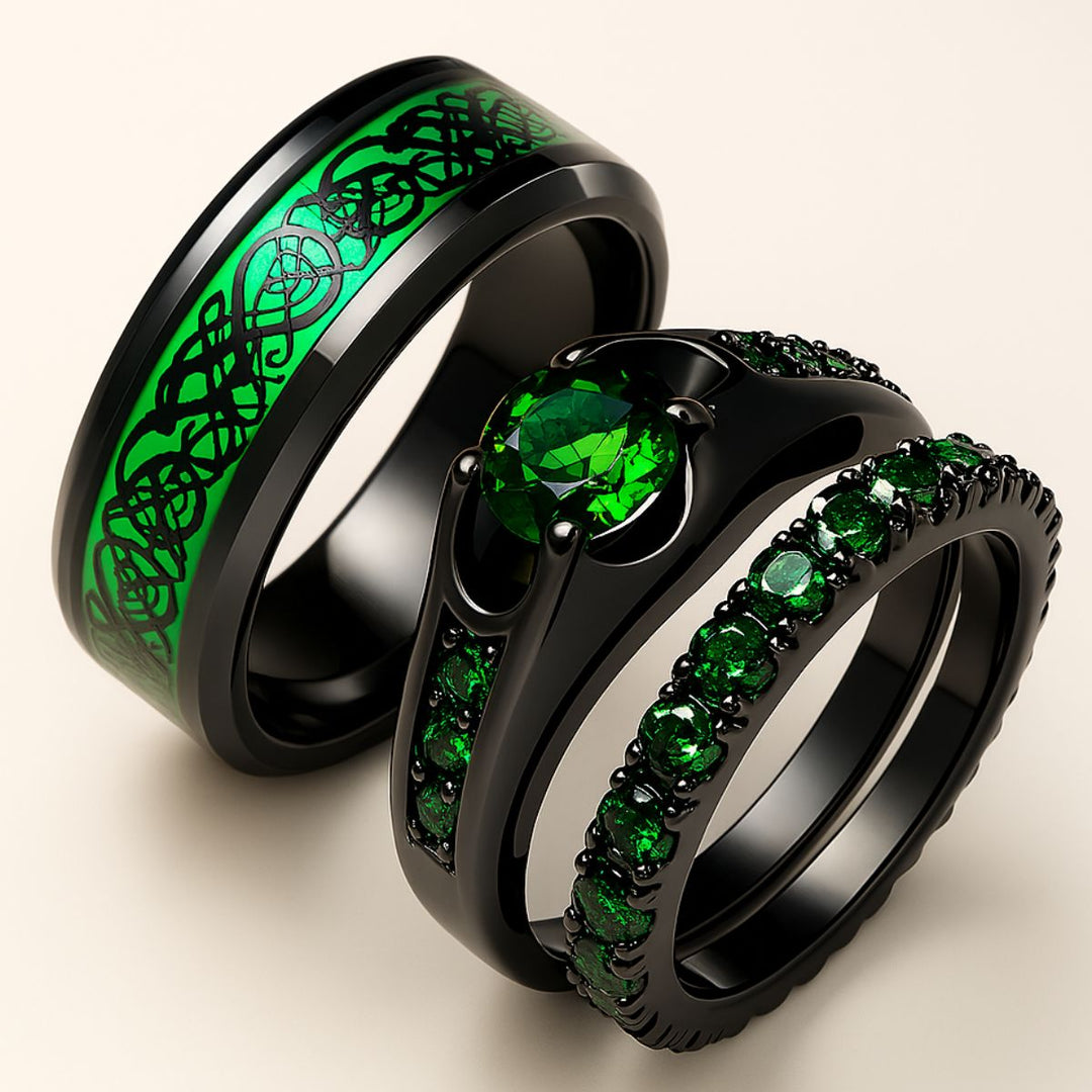 Emerald Love ring set by CouplesChoices.com, featuring a radiant green gemstone trio on black-plated bands and a matching men’s ring with shimmering emerald Celtic knotwork—bold, modern, eternal.