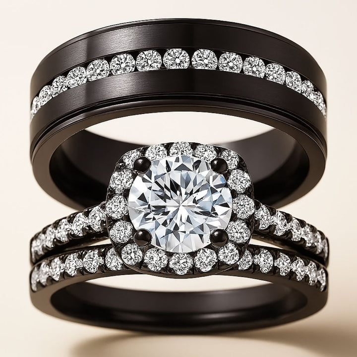 Euphoria Ring Set by CouplesChoices.com featuring a round-cut center stone on a black pavé halo setting, paired with a coordinating diamond-lined wedding band and a bold men’s ring with a full pavé channel.