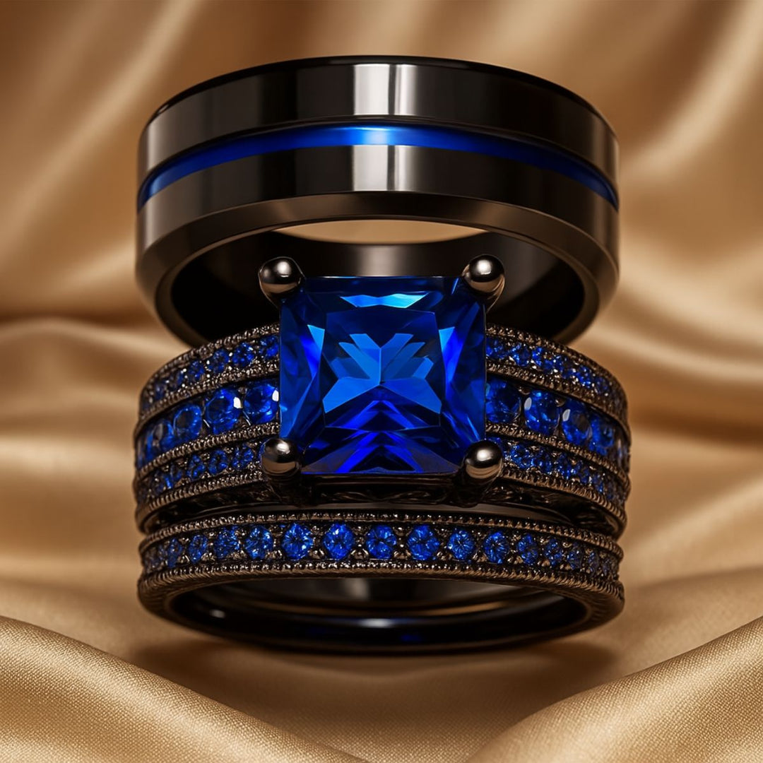 Love Dance ring set by CouplesChoices.com, featuring a bold black titanium band with electric blue inlay and a radiant princess-cut sapphire atop pavé-set blue stones—designed to move hearts.