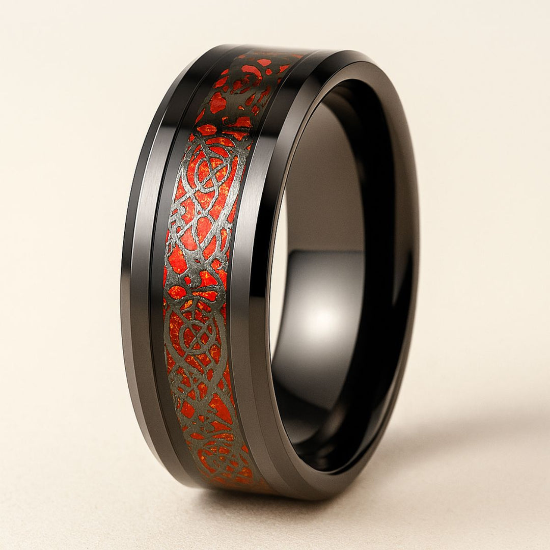 Love Story Ring Set by CouplesChoices.com showcasing a heart-shaped red gemstone on a black gold split-shank ring with red pavé accents, paired with a black men’s band featuring engraved Celtic motifs in red—crafted to symbolize bold love.