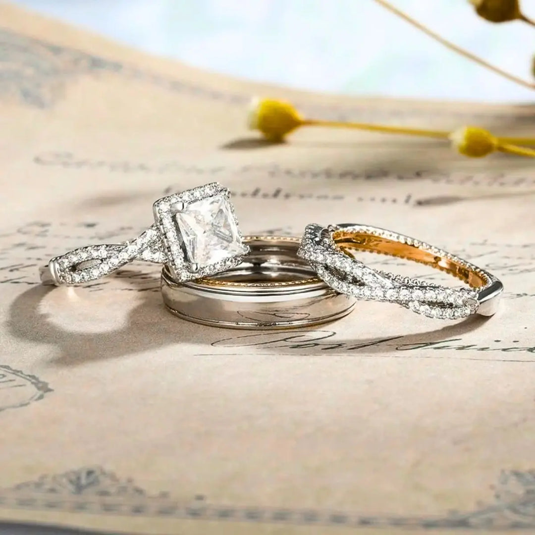 Lumina ring set by CouplesChoices.com, showcasing a princess-cut center stone on a pavé infinity band in radiant gold, paired with a matching gold men’s band for a timeless, luminous union.