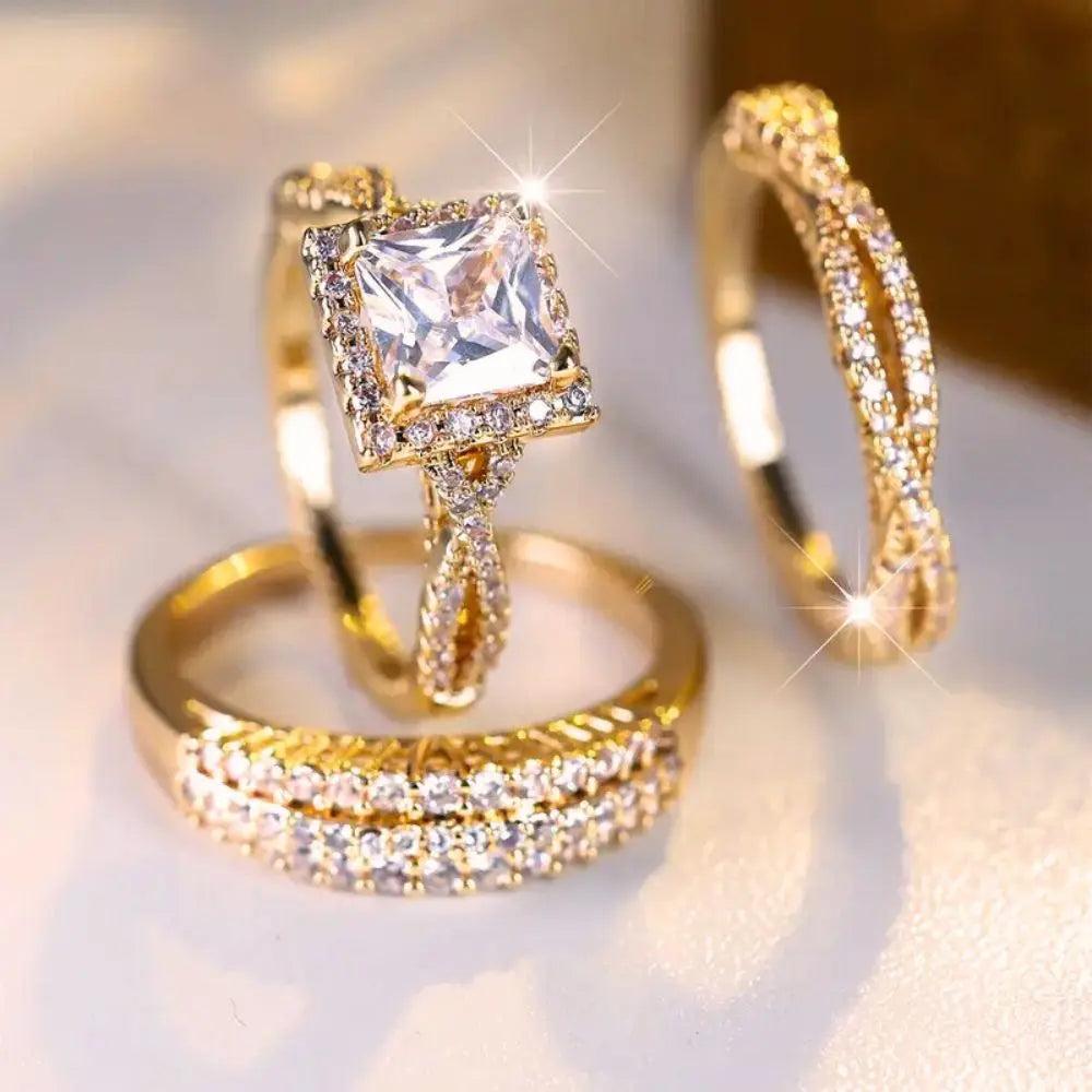 Luxurious 3-piece Euphoria Ring Set from CouplesChoices.com, showcasing a cushion-cut center stone on a pavé diamond gold band, paired with two matching eternity rings crafted for brilliance, elegance, and lasting romance.