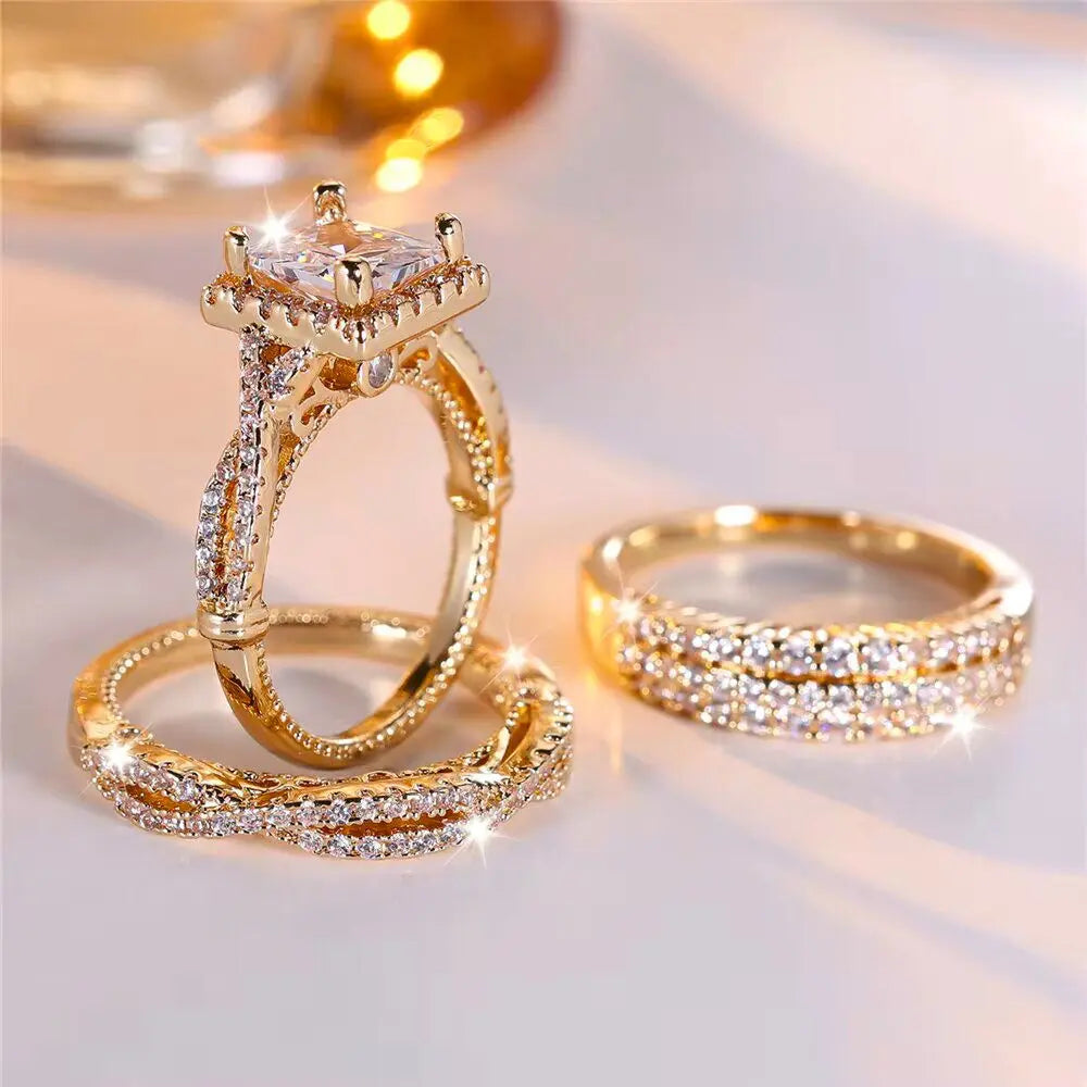 Luxurious 3-piece Euphoria Ring Set from CouplesChoices.com, showcasing a cushion-cut center stone on a pavé diamond gold band, paired with two matching eternity rings crafted for brilliance, elegance, and lasting romance.