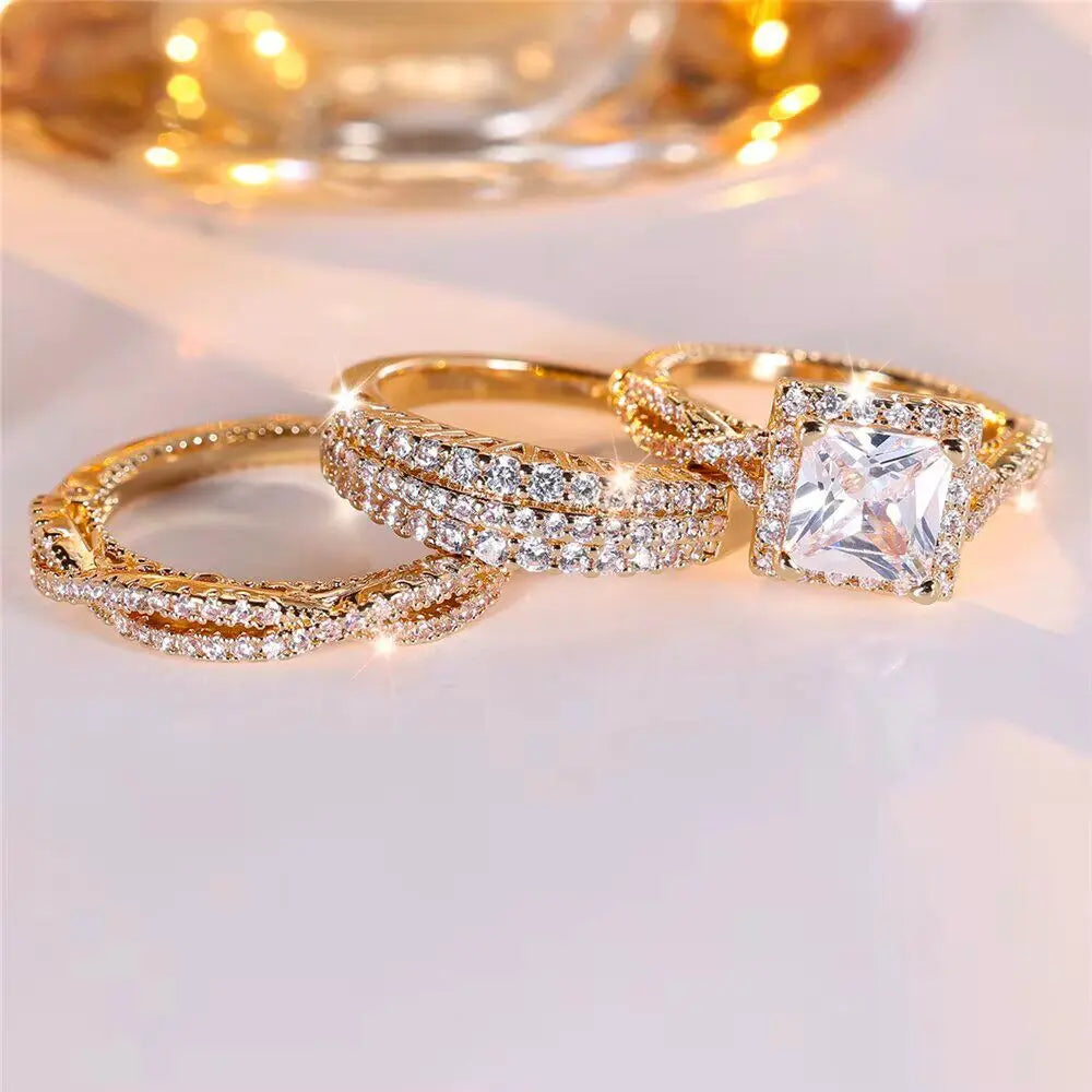 Luxurious 3-piece Euphoria Ring Set from CouplesChoices.com, showcasing a cushion-cut center stone on a pavé diamond gold band, paired with two matching eternity rings crafted for brilliance, elegance, and lasting romance.