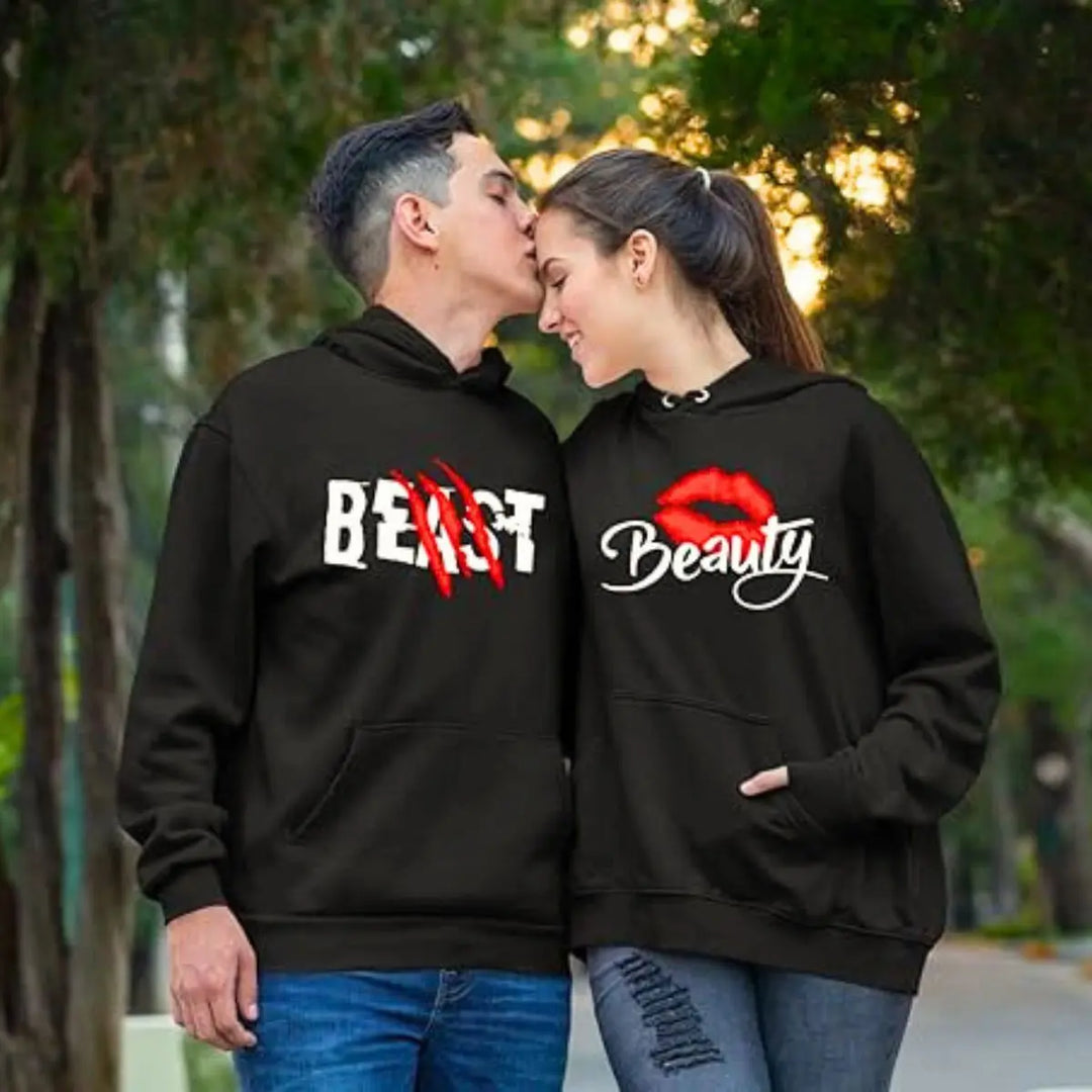 Matching black couple hoodies from CouplesChoices.com with bold white text—his reads “BEAST” with red claw marks, and hers says “Beauty” with a red lipstick kiss graphic. A fun, edgy set for couples who embrace fierce love and playful contrasts.