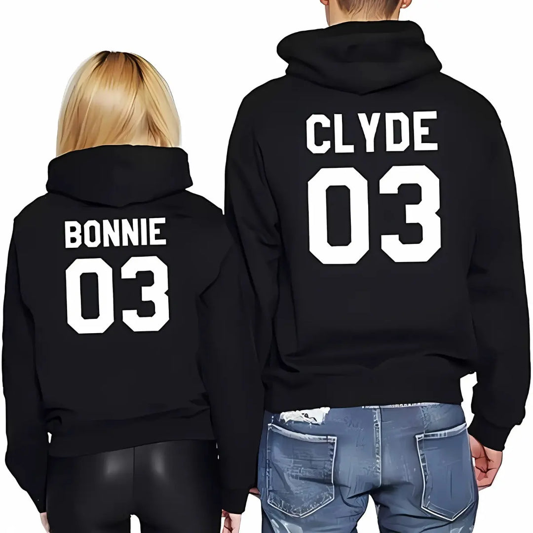 Matching black couple hoodies from CouplesChoices.com with bold white varsity-style text — “BONNIE 03” and “CLYDE 03” printed on the back. A sporty, statement-making set for couples who embrace loyalty, legacy, and standout style.