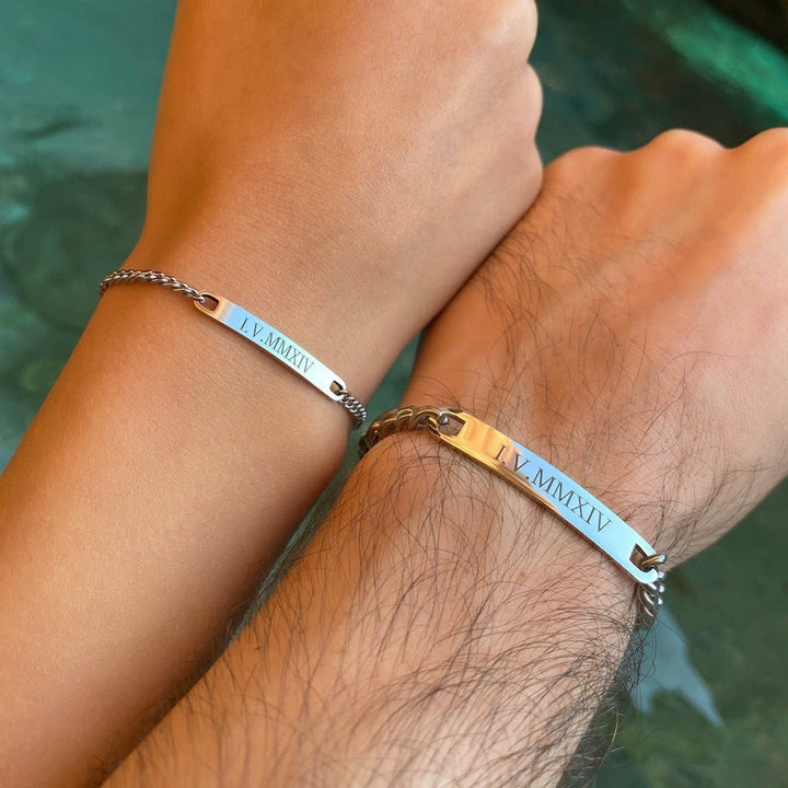 Matching engraved couple bracelets with minimalist chain link design in silver, gold, and black finishes, featuring personalized nameplate tags—romantic gift for couples by CouplesChoices.com.