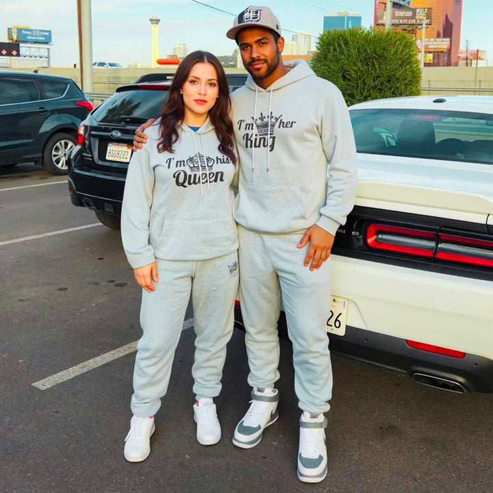 Matching gray King and Queen tracksuits for couples from CouplesChoices.com, featuring crown graphics and bold 'I'm her King' and 'I'm his Queen' prints on hoodies and joggers—crafted for comfort, unity, and standout street style.