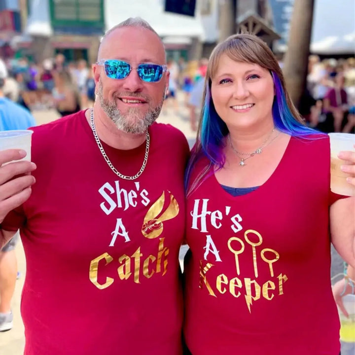 Matching maroon couple shirts with gold foil text: 'She’s a Catch' featuring a golden snitch, and 'He’s a Keeper' with Quidditch goalposts – perfect for Potterhead pairs.