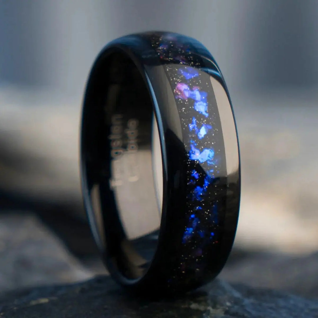 Nebula Rings by CouplesChoices.com—tungsten carbide wedding bands infused with cosmic opal inlays, evoking the deep blue glow of a distant galaxy. A bold, celestial design for couples who share a love as infinite as the stars.