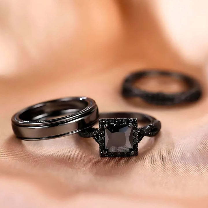 Noir Rings by CouplesChoices.com, featuring a bold black princess-cut engagement ring with pavé black gemstone detailing and matching black tungsten bands—designed to embody elegance, power, and modern romance.