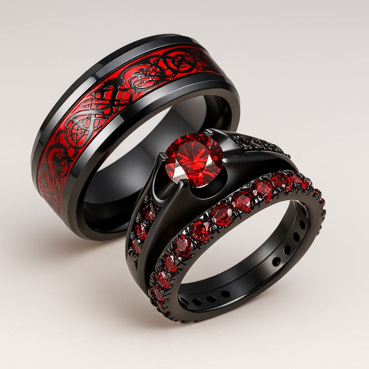 Red Beauty ring set from CouplesChoices.com, featuring a bold black engagement ring with red round-cut center stone and pavé red side stones, paired with a matching eternity band and a black tungsten men’s ring with engraved red Celtic inlay.