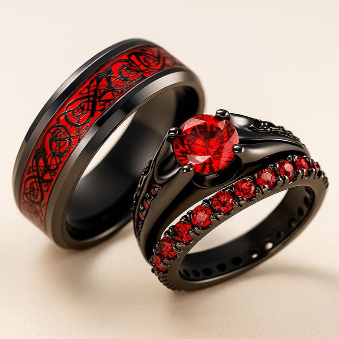 Red Beauty ring set from CouplesChoices.com, featuring a bold black engagement ring with red round-cut center stone and pavé red side stones, paired with a matching eternity band and a black tungsten men’s ring with engraved red Celtic inlay.