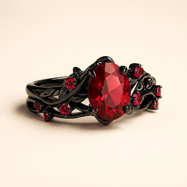 Red Heart wedding ring set from CouplesChoices.com, featuring a black tungsten men’s band with Celtic red inlay and a matching women’s ring with an oval-cut ruby centerpiece and vine-inspired black setting.