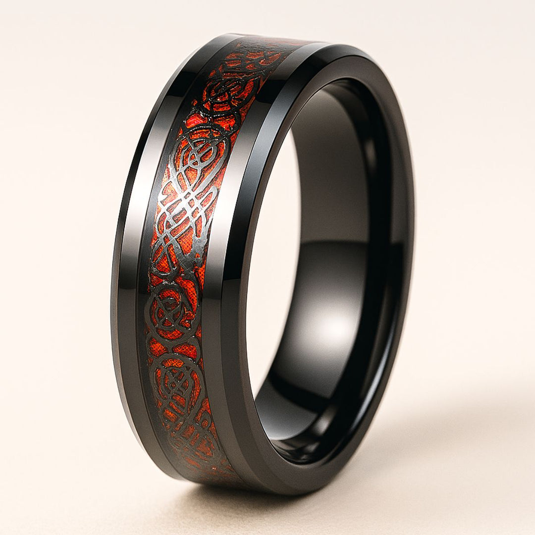 Red Heart wedding ring set from CouplesChoices.com, featuring a black tungsten men’s band with Celtic red inlay and a matching women’s ring with an oval-cut ruby centerpiece and vine-inspired black setting.