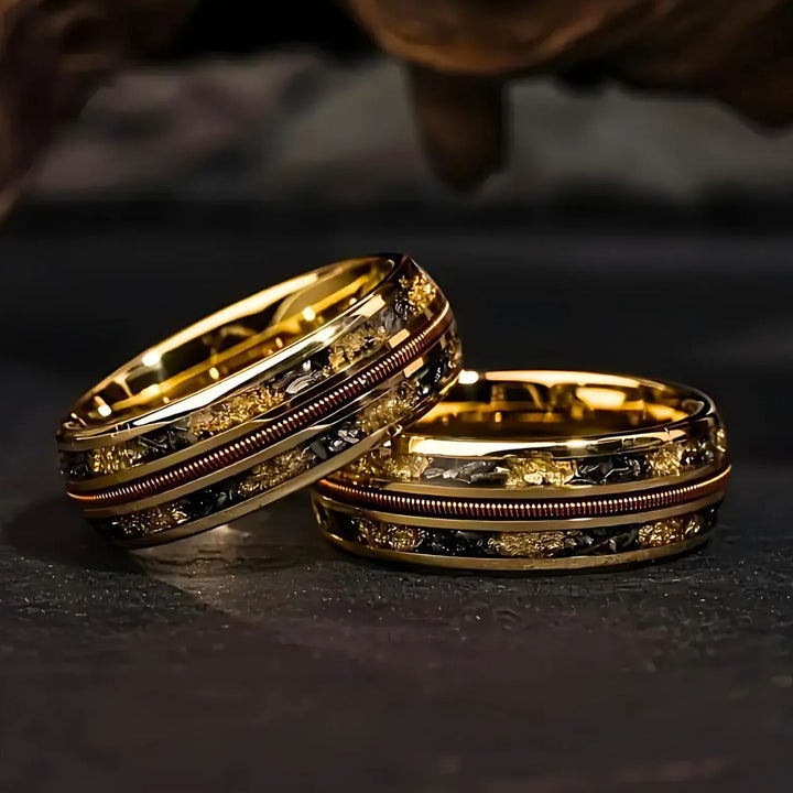 Starforged gold couple rings by CouplesChoices.com, featuring black and gold meteorite inlays and a central textured copper band—symbolizing strength, unity, and timeless elegance.