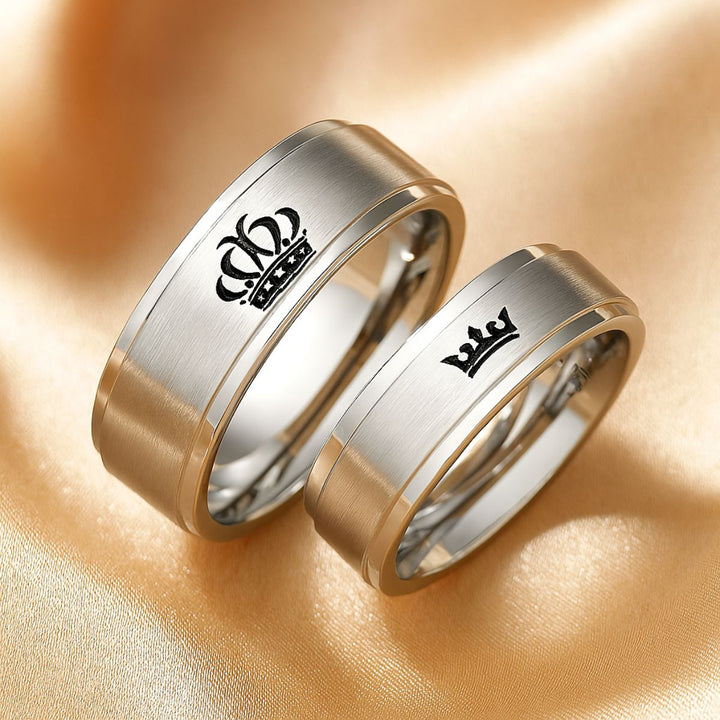 Timeless Exhilaration Rings by CouplesChoices.com—brushed silver bands engraved with elegant crown icons and inner "Her King" & "His Queen" inscriptions. A sleek, modern symbol of eternal love, loyalty, and royalty-inspired devotion.